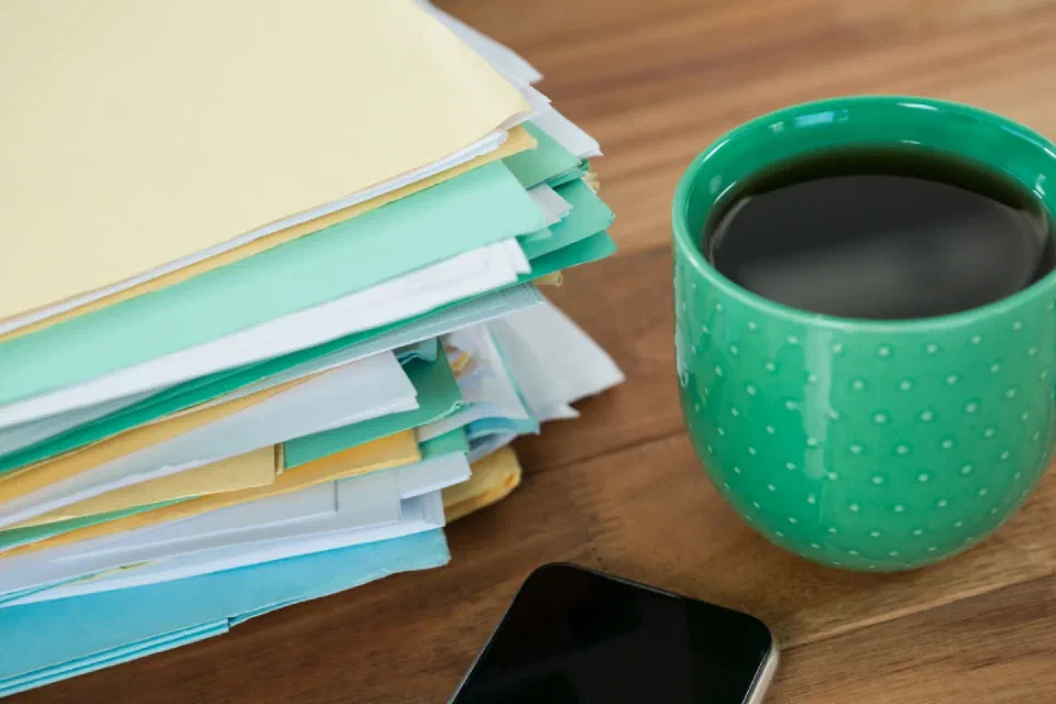 Folders and a coffee cup on a desk